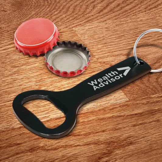 Black bottle opener with 'Wealth Advisor' text on a wooden surface with bottle caps.