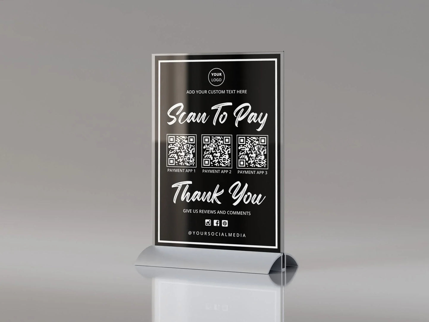 Black acrylic table sign with scan to pay QR codes and social media icons on a gray background.