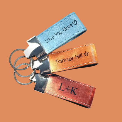 Personalized leather keychains with engraved text on orange background