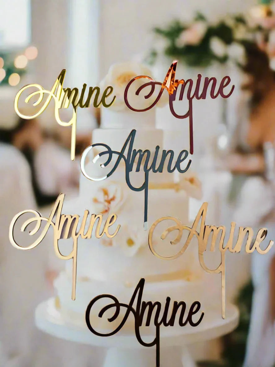 Custom amine cake toppers in gold and metallic colors on a white floral wedding cake