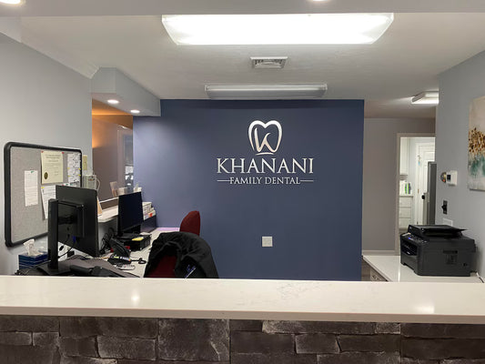 Modern dental office reception with KHANANI FAMILY DENTAL logo on blue wall