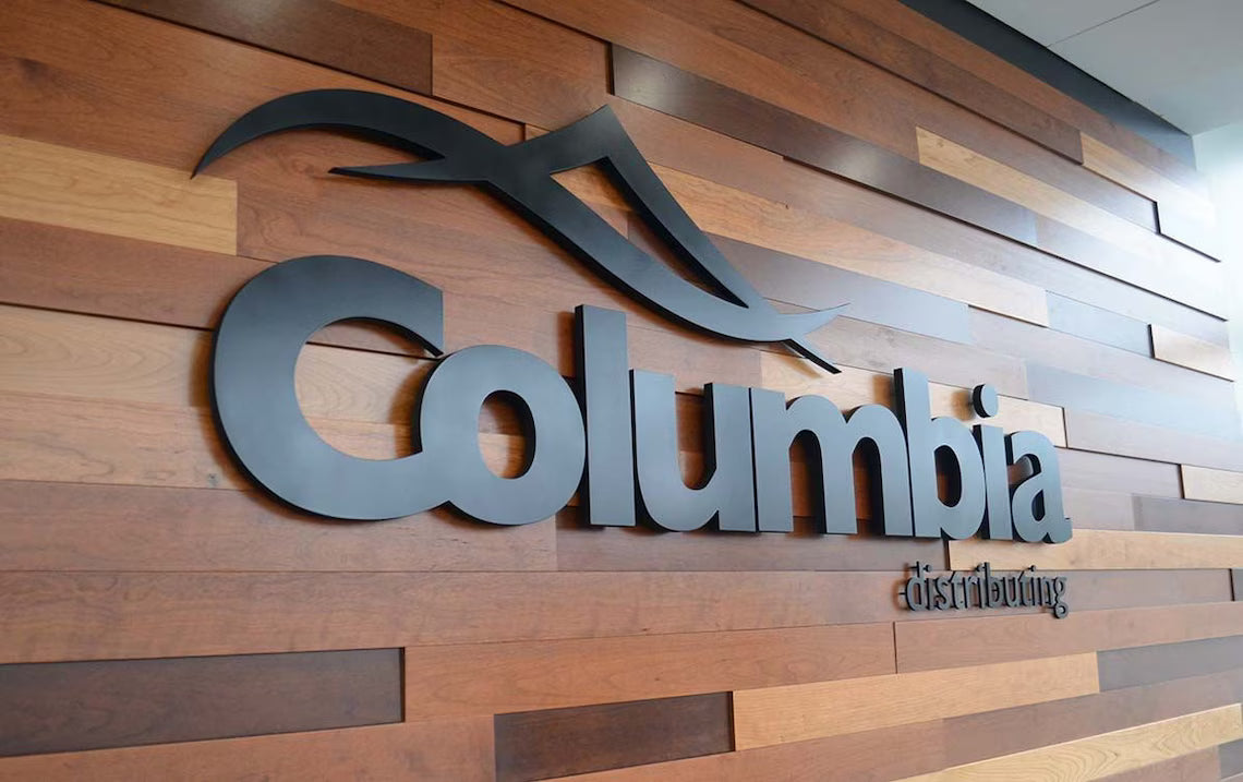 Modern business signage for Columbia on a wood accent wall in corporate office lobby