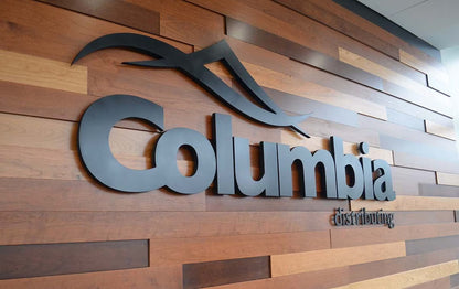 Modern business signage for Columbia on a wood accent wall in corporate office lobby