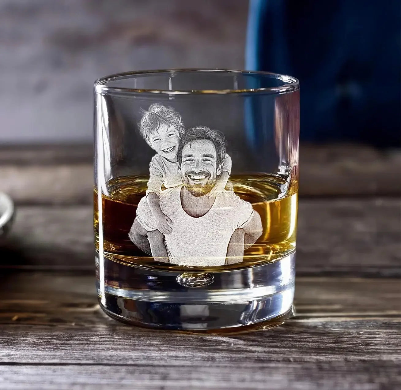 Etched whiskey glass with smiling father and son on rustic wood table
