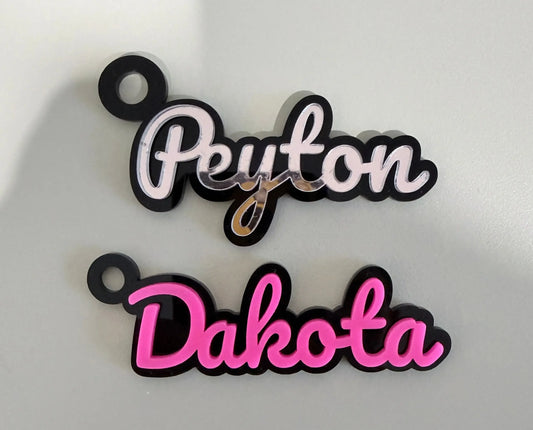 Custom name keychains Peyton and Dakota in pink and white on a light gray background