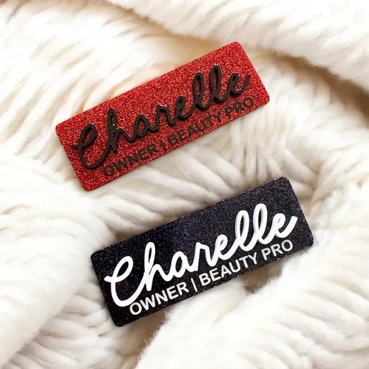 Custom acrylic name badges with glitter, red and black, on white fabric background